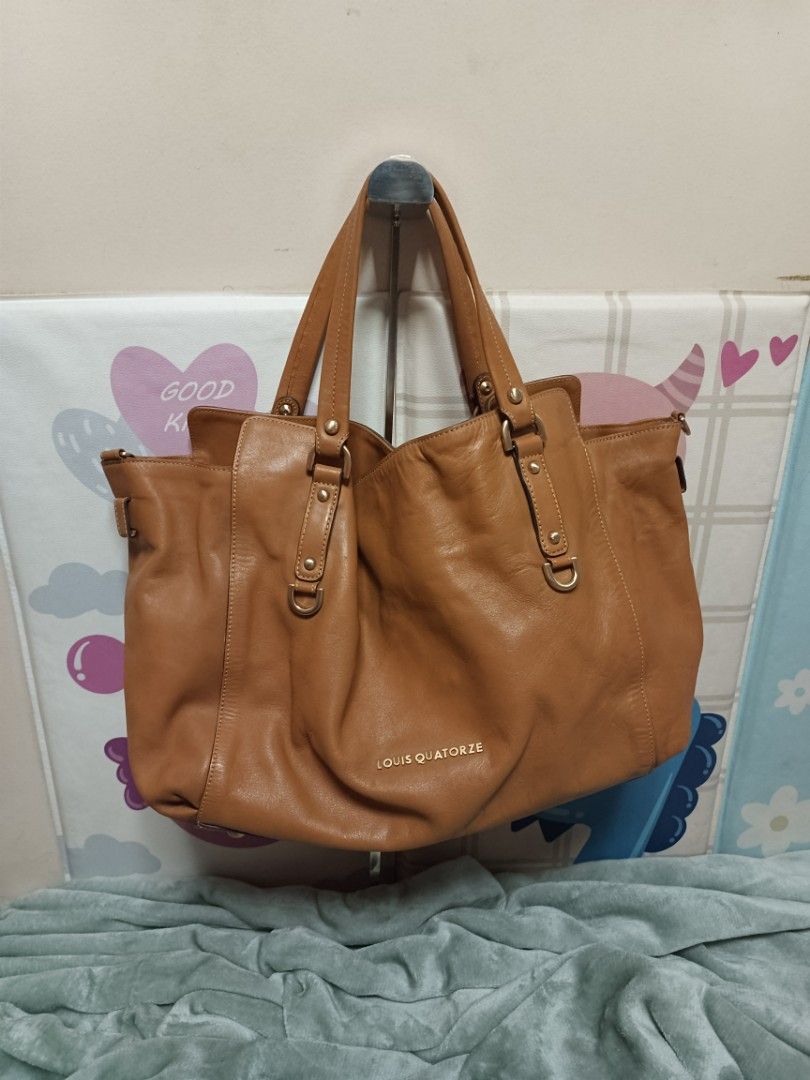Louis Quatorze Leather Tote Bag (Category: Tote Bags) located in Batangas. Submitted by espresso.macchiato (Listing ID 1425541423, Image 1). Description: Genuine leather tote bag from Louis Quatorze. Features a spacious interior with a patterned lining and an interior zip pocket. Includes a detachable shoulder strap. The bag has a top handle design with gold-tone hardware. The exterior is a tan color. The brand name is visible on the front and in