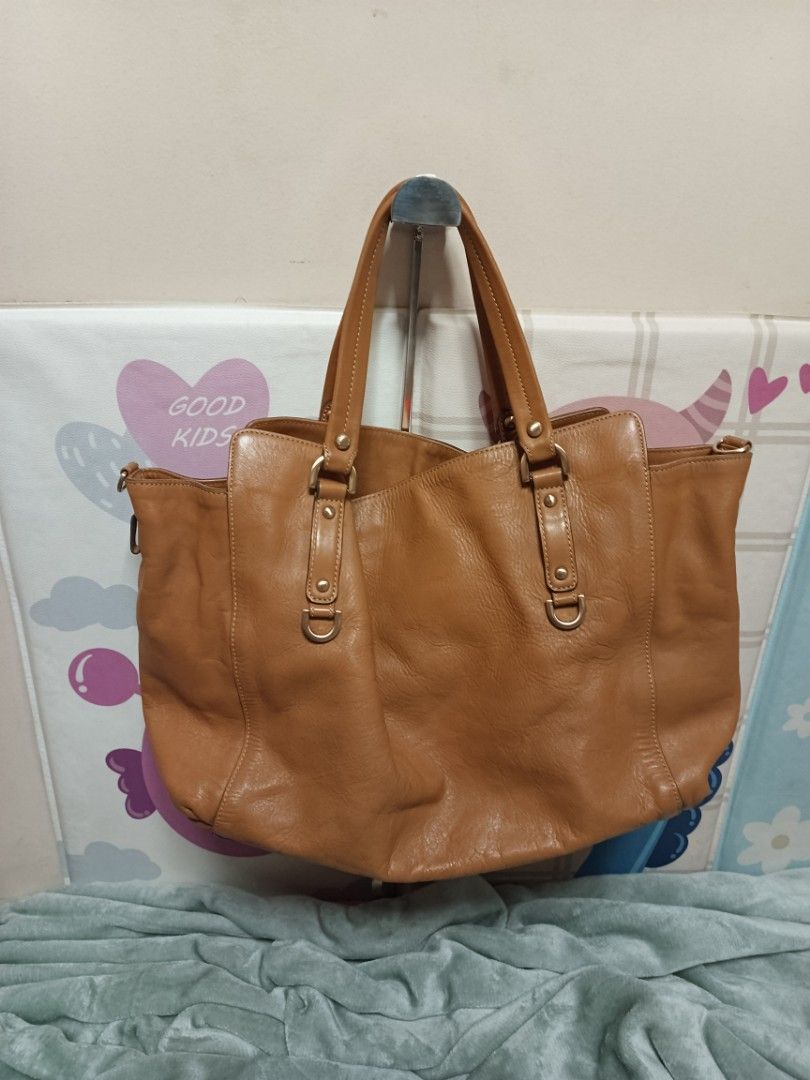 Louis Quatorze Leather Tote Bag (Category: Tote Bags) located in Batangas. Submitted by espresso.macchiato (Listing ID 1425541423, Image 3). Description: Genuine leather tote bag from Louis Quatorze. Features a spacious interior with a patterned lining and an interior zip pocket. Includes a detachable shoulder strap. The bag has a top handle design with gold-tone hardware. The exterior is a tan color. The brand name is visible on the front and in