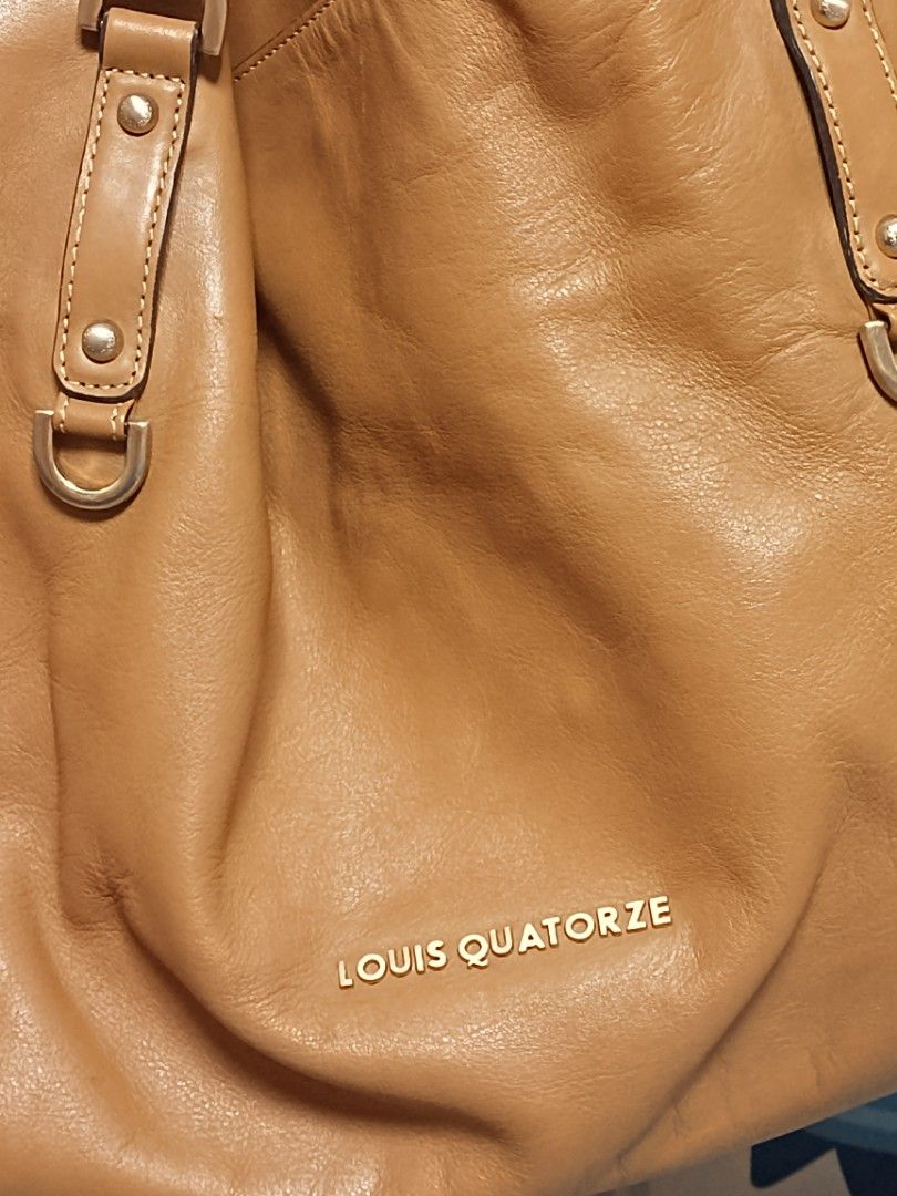 Louis Quatorze Leather Tote Bag (Category: Tote Bags) located in Batangas. Submitted by espresso.macchiato (Listing ID 1425541423, Image 2). Description: Genuine leather tote bag from Louis Quatorze. Features a spacious interior with a patterned lining and an interior zip pocket. Includes a detachable shoulder strap. The bag has a top handle design with gold-tone hardware. The exterior is a tan color. The brand name is visible on the front and in