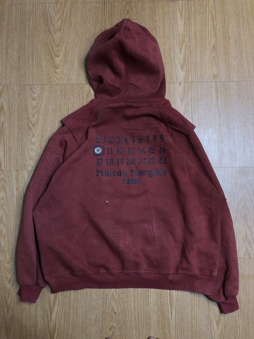 Maison Margiela Zip Hoodie (Category: Coats, Jackets and Outerwear) located in Quezon City. Submitted by yeahsource222 (Listing ID 1425623444, Image 2). Description: Maroon zip-up hoodie from Maison Margiela. Features a hood and front pockets. The back displays the Maison Margiela logo and the iconic number patch. The hoodie has a unique shoulder design. It has a full zip closure and ribbed cuffs..