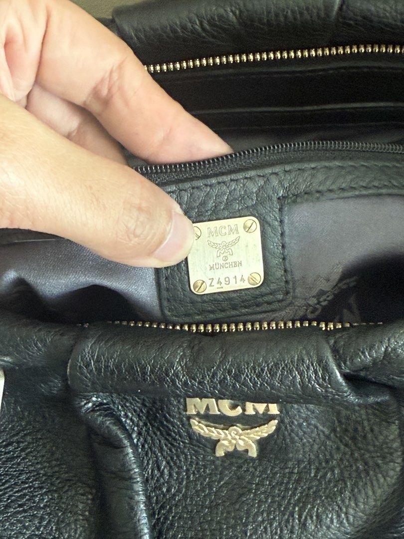 MCM Black Leather Handbag (Category: Luxury Bags & Wallets) located in Makati City. Submitted by markussangabriel (Listing ID 1425450929, Image 2). Description: Black leather handbag from MCM. Features a top handle and a shoulder strap. Includes MCM authenticity cards. The bag has gold-tone hardware and the MCM logo is visible on the front. The interior has a metal MCM tag with the serial number Z4914. Lost strap. .