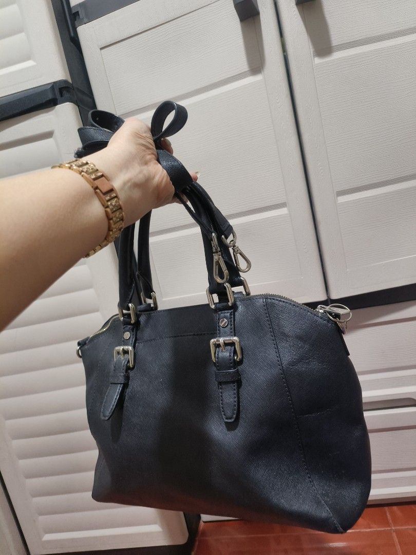 Michael Kors Black Bag Ciara Siffiano (Category: Luxury Bags & Wallets) located in Manila. Submitted by teacherkei (Listing ID 1425595539, Image 2). Description: Black Michael Kors satchel bag with silver-tone hardware. Features a top handle and a detachable shoulder strap. The interior has a zip pocket and is lined with the Michael Kors logo. The bag has a zip closure and metal feet on the bottom. The exterior shows some signs of wear. Padala fr