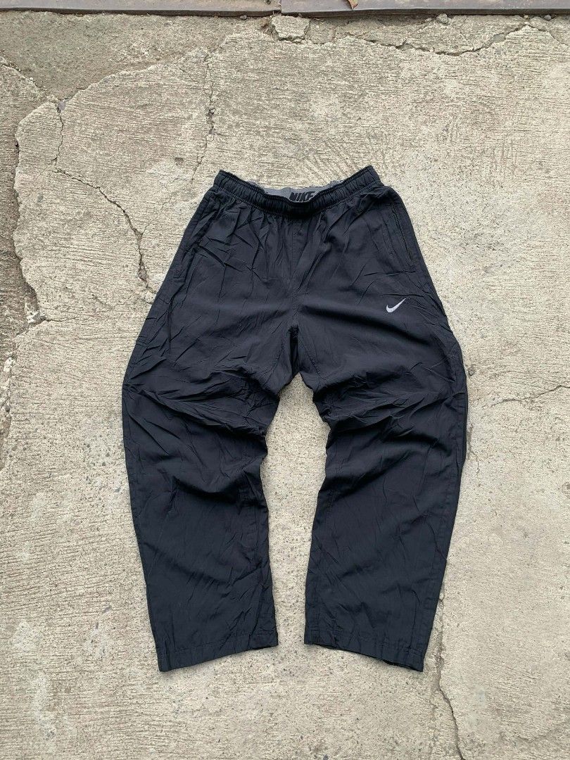 Nike Dri-FIT Black Pants baggy type (Category: Joggers) located in Manila. Submitted by louiseluch69680 (Listing ID 1425470350, Image 1). Description: Black Nike Dri-FIT pants. Features a Nike logo on the front and a drawstring waistband with the Nike logo. Includes zippered pockets. The tag indicates the pants are made in China and are size L. The material is 100% polyester. The pants are designed for comfort and performance. excellent condition
