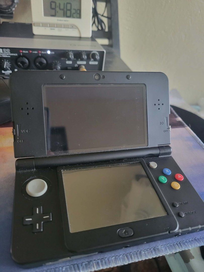 New Nintendo 3DS (Category: Nintendo) located in Manila. Submitted by maeelizabe63182 (Listing ID 1425448932, Image 1). Description: - 128 gb cfw already -Audio interface working New Black Nintendo 3DS console. The console is in working condition and shows the home screen with several game icons. The top screen displays a game. The console has the volume slider, 3D slider, and other buttons. The back of the console has the game card slot and head