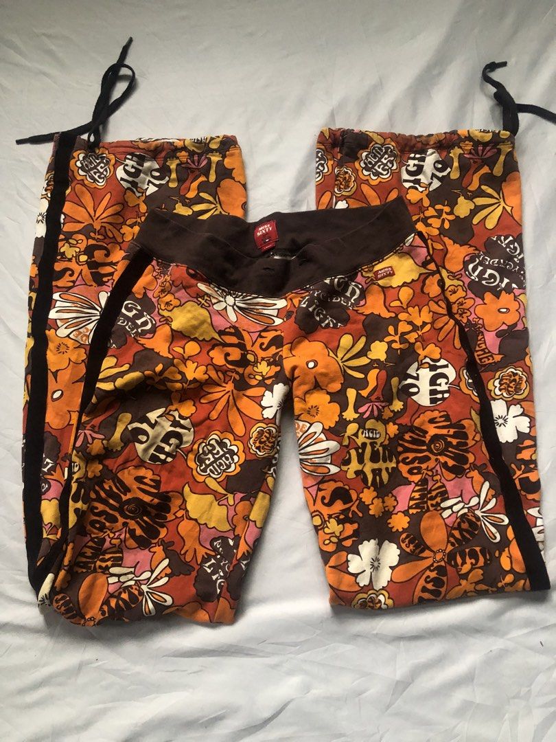 Miss Sixty Psychedelic Floral Track Pants (Category: Jeans) located in Cagayan de Oro. Submitted by grimxens.desire (Listing ID 1425446024, Image 1). Description: ISSUE: missing waist drawstring Miss Sixty Track Pants with a vibrant floral print. Features a brown waistband and black stripes on the sides. The pants have a unique design with drawstrings at the bottom of the legs..