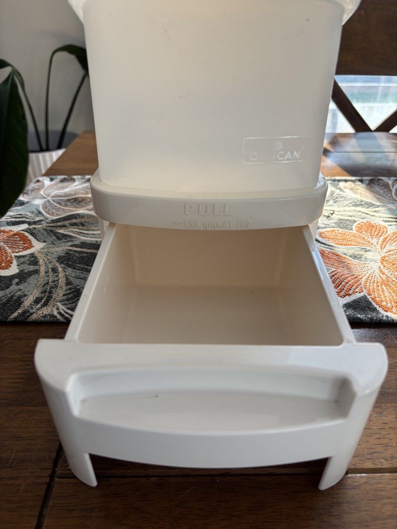 Orocan Ricegard Rice Dispenser (Category: Food Organization & Storage) located in Tagaytay City. Submitted by kite_estrella (Listing ID 1425526854, Image 2). Description: Orocan Ricegard rice dispenser. It has a pull-out drawer that dispenses approximately 150 gms / 1 cup of rice. The dispenser has a capacity of 10 kg. It has a clear body with measurement indicators. The dispenser is white and has a lid..