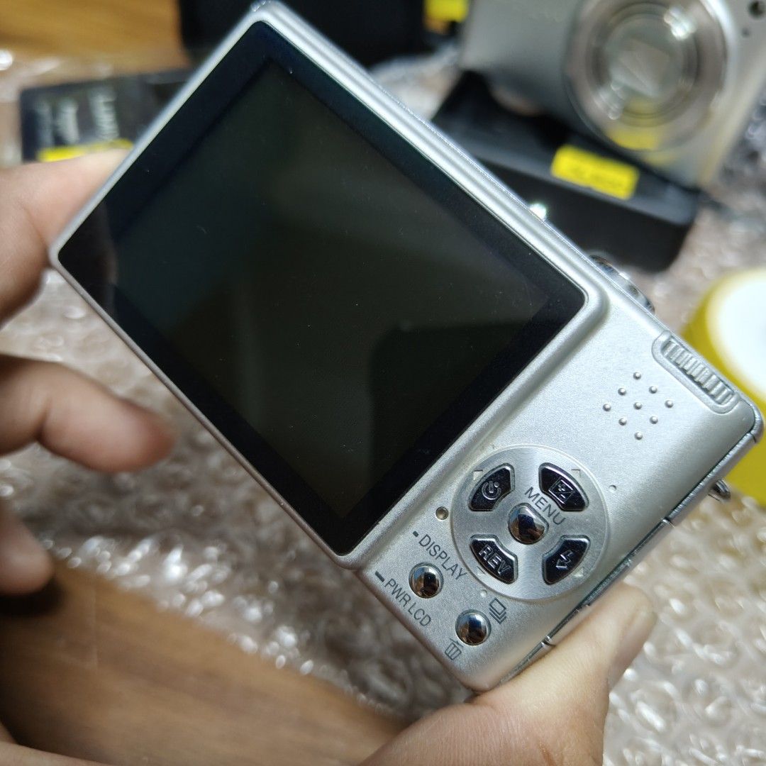 Panasonic Lumix DMC FX9 Digital Camera Digicam (Category: Cameras) located in Manila. Submitted by rossinicalabig (Listing ID 1425540654, Image 3). Description: 5,000 Pesos Panasonic Lumix DMC FX9 digital point & shoot camera. Fast autofocus! Includes a charger and battery. It has a silver finish and a built-in flash. The screen displays the camera's settings and the image being captured. Check,test,pickup at our Photo/Video studio in Sta.Mesa Ml