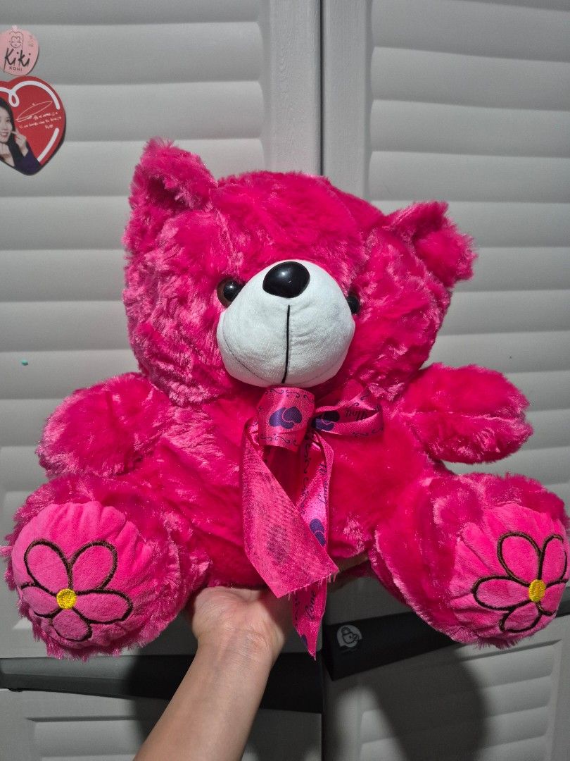 Pink Teddy Bear with Flower Accents (Category: Plushies & Soft Toys) located in Taguig. Submitted by perfect_restyle (Listing ID 1425473077, Image 1). Description: Adorable pink teddy bear features flower accents on its paws and a cute bow. It has a white face with black eyes and a soft, plush texture. Perfect for cuddling or as a decorative piece..