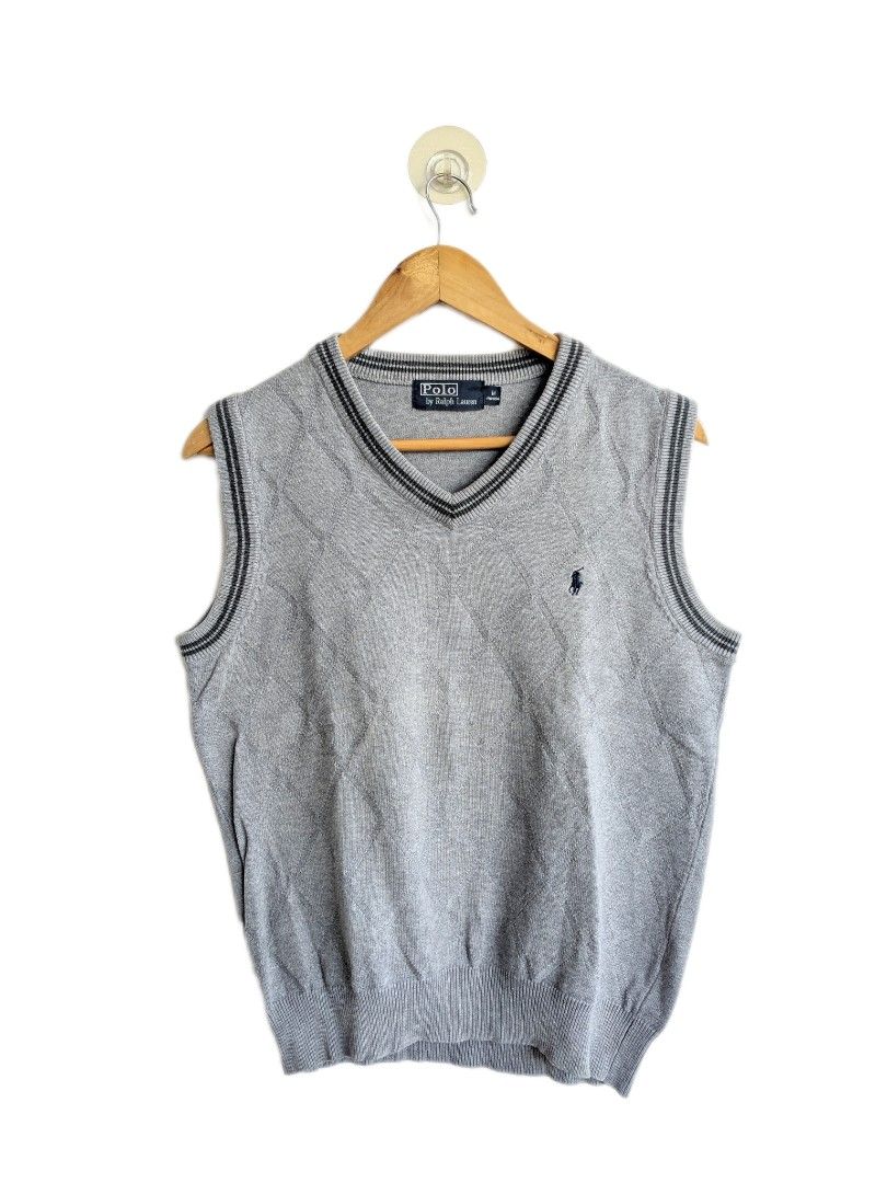 Polo Ralph Lauren Argyle Vest (Category: Vests) located in Imus. Submitted by valentino.bros. (Listing ID 1425592804, Image 1). Description: Gray Polo Ralph Lauren vest with argyle pattern. Features a V-neck design with navy blue trim. Includes the Polo Ralph Lauren logo on the chest. The tag shows size information. Made of a knit material, suitable for layering. The vest has a classic, preppy style. - Dimes: 20" x 23.5" - Issue/s: - Color rate: 