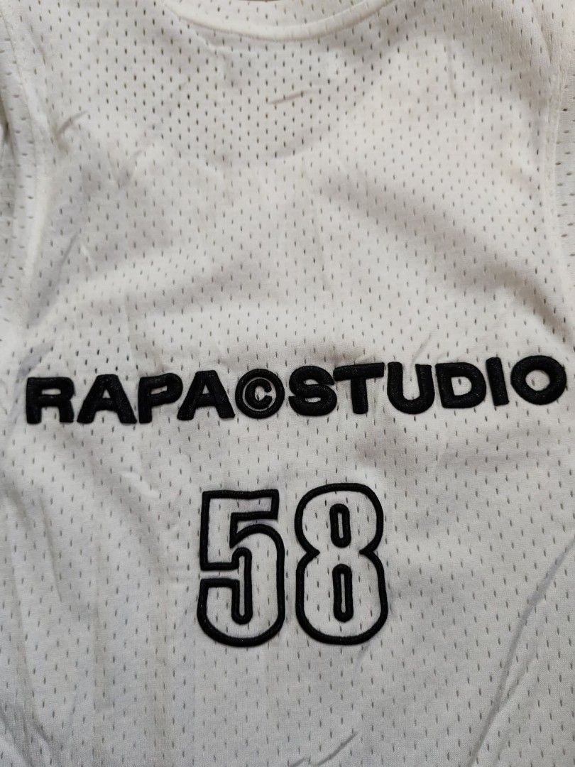 Rapa Studio White Tank Top (Category: Vests) located in Sipalay. Submitted by boldowl.e4f283 (Listing ID 1425448261, Image 3). Description: White tank top from Rapa Studio. Features the brand name on the front and back, along with the number "58" on the back. The tank top has a mesh-like texture. It has a size L label. The care label indicates it can be machine washed and ironed..