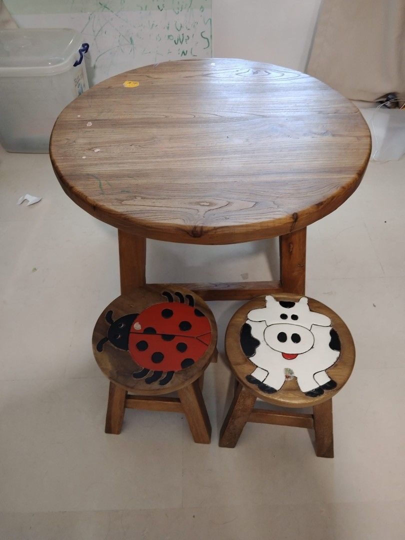 Solid Wood Table with Stools (Category: Tables & Sets) located in Singapore. Submitted by fluffycarrotz (Listing ID 1425550656, Image 1). Description: Adorable wooden table set, perfect for kids! Includes a round table and two stools, one with a ladybug design and the other with a cow. Great for playtime or a small dining area/coffee table. 85cm x 45cm.