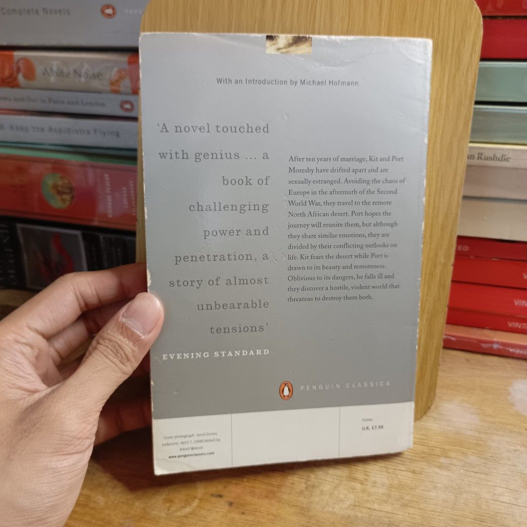 The Sheltering Sky by Paul Bowles (Category: Storybooks) located in Manila. Submitted by shelfenjoyment (Listing ID 1425503166, Image 3). Description: Copy of Paul Bowles' "The Sheltering Sky" published by Penguin Classics. The book features a cover with a desert landscape. The back cover includes a quote from the Evening Standard. The book has an introduction by Michael Hofmann..