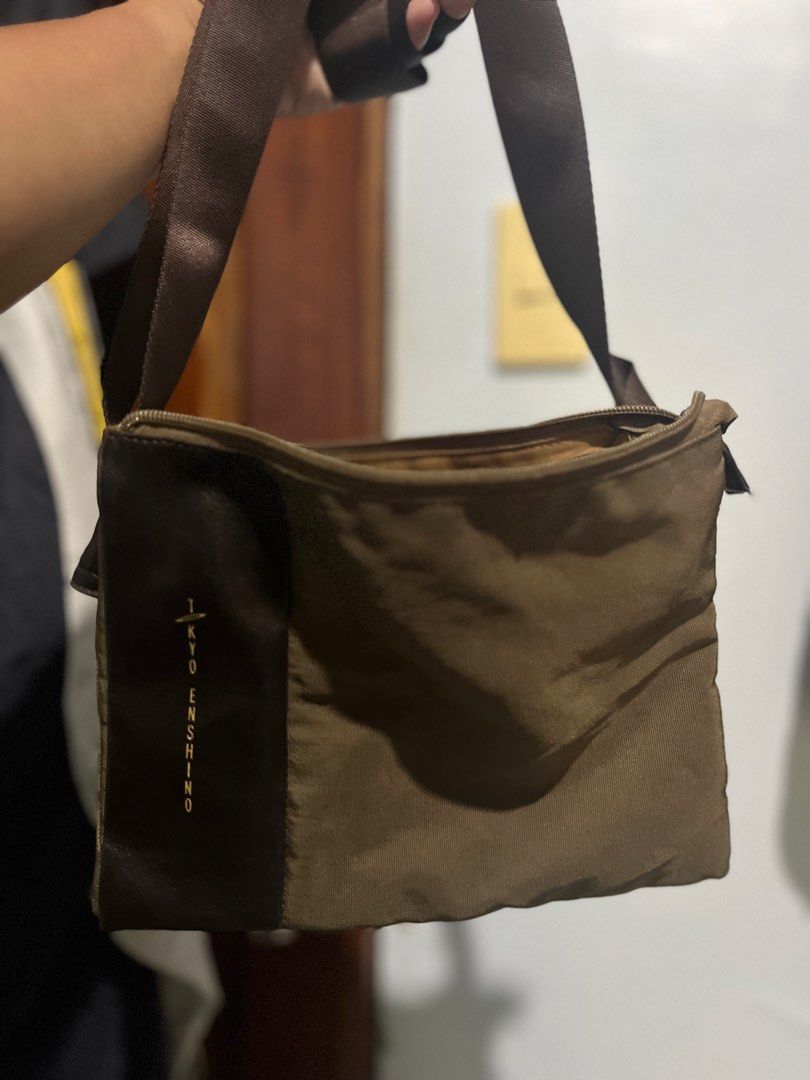Tokyo Enshinsho Messenger Bag (Category: Sling Bags) located in Daanbantayan. Submitted by christinet58475 (Listing ID 1425539243, Image 3). Description: Messenger bag features a brown and olive green color scheme. It has a main compartment and multiple interior pockets. The bag has a shoulder strap and a zipper closure. The brand name "Tokyo Enshinsho" is visible on the front of the bag..