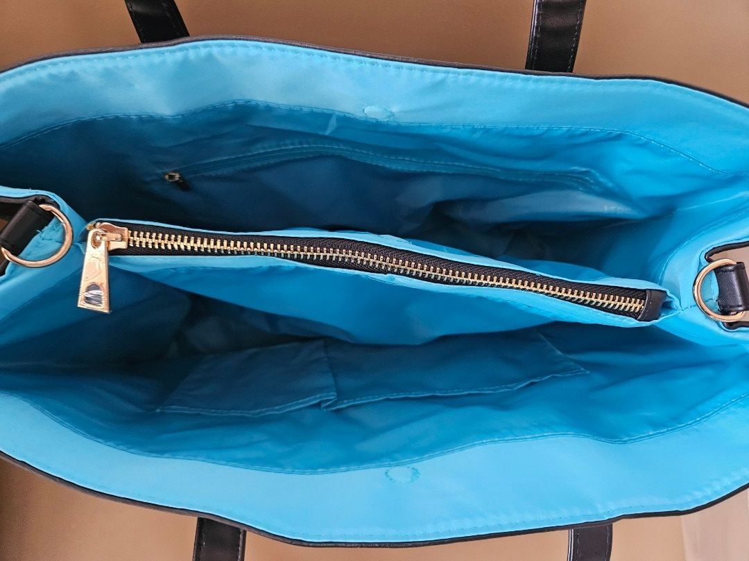 Versace Fragrances Tote Bag (Category: Luxury Bags & Wallets) located in Manila. Submitted by allysa_trinkets (Listing ID 1425491513, Image 3). Description: Black tote bag from Versace Fragrances. Features a spacious interior with a light blue lining and multiple pockets, including a zippered compartment. Includes a detachable shoulder strap. The bag has a rectangular shape with two top handles and a small metal logo on the front..