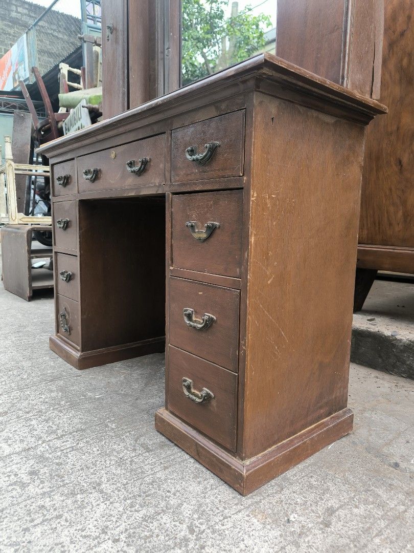 Vintage Wooden Vanity Table with Mirror (Category: Tables & Sets) located in Manila. Submitted by makkieenri69972 (Listing ID 1425482535, Image 3). Description: Vintage vanity table features a large mirror and multiple drawers for storage. It has a classic design with a wooden frame and a light-colored tabletop. The table includes two side cabinets and several drawers of varying sizes. It's a functional and stylish piece for any bedroom or dressi