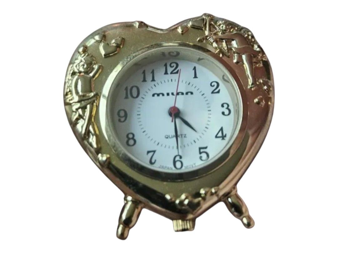 ✨ MILAN Heart-Shaped Quartz Cherub Mini Clock ✨ (Category: Clocks) located in Bulacan. Submitted by shopyourstyleph (Listing ID 1429522816, Image 1). Description: Charming heart-shaped clock features a gold-toned frame with decorative cherub accents. The clock face is white with black numerals and hands, and the brand name "Miyota" is visible. It is a quartz clock. The back of the clock indicates it is a quartz clock and has a battery compartment