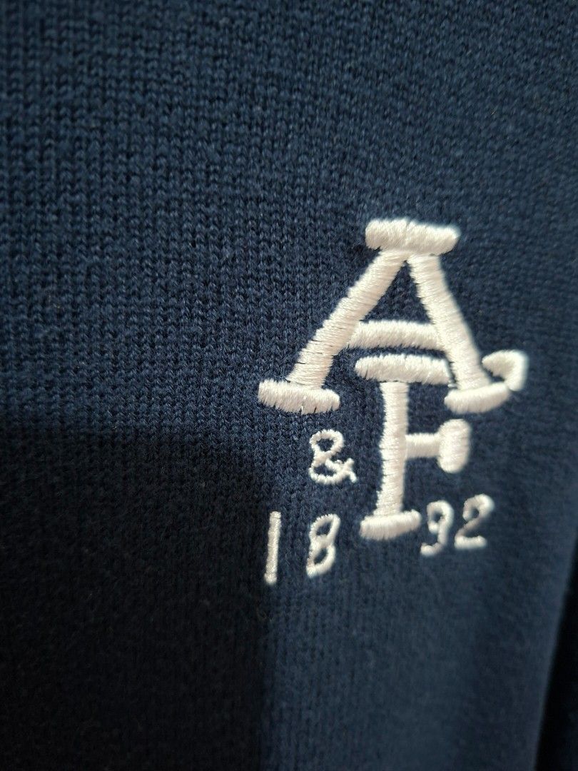 Abercrombie & Fitch Navy Sweater (Category: Coats, Jackets and Outerwear) located in Paranaque City. Submitted by potatoiceblended (Listing ID 1429533511, Image 3). Description: Navy blue sweater from Abercrombie & Fitch. Features a crew neck with white stripes and an embroidered logo on the chest. Made in Macau. Size M..