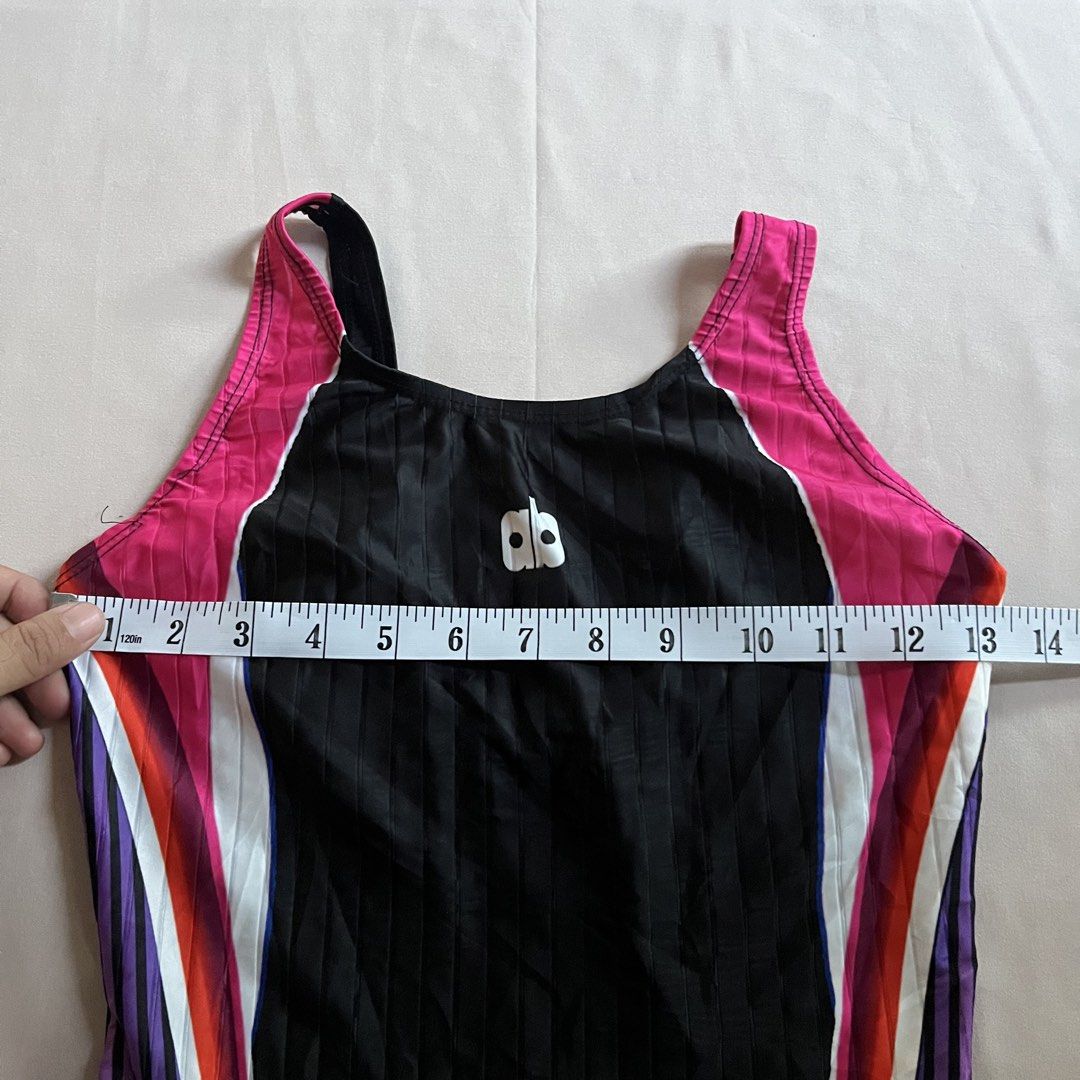 Arnaldo Bassini Kneesuit (Large) (Category: Bikinis & Swimsuits) located in Panabo. Submitted by munch.ph (Listing ID 1429584088, Image 2). Description: Arnold Bassini kneesuit features a black base with pink, white, purple, and orange accents. It has a racerback design and a logo on the chest. The swimsuit has a ribbed texture and a form-fitting design. The tag indicates a size range of 90-95 cm. The leg length measures approximately 7 inches..