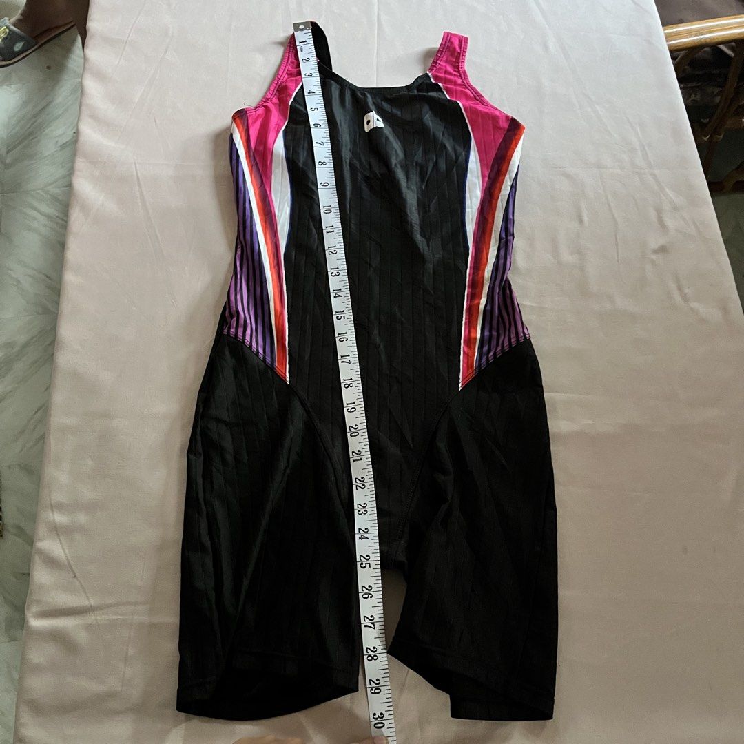 Arnaldo Bassini Kneesuit (Large) (Category: Bikinis & Swimsuits) located in Panabo. Submitted by munch.ph (Listing ID 1429584088, Image 3). Description: Arnold Bassini kneesuit features a black base with pink, white, purple, and orange accents. It has a racerback design and a logo on the chest. The swimsuit has a ribbed texture and a form-fitting design. The tag indicates a size range of 90-95 cm. The leg length measures approximately 7 inches..