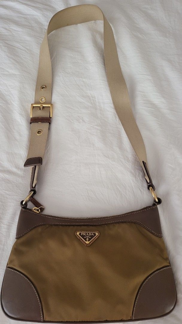 Authentic Prada Crossbody Bag (Category: Luxury Bags & Wallets) located in Quezon City. Submitted by bonching (Listing ID 1429598697, Image 1). Description: Prada shoulder bag features a nylon body with leather trim. It has a zip closure and an adjustable shoulder strap. The interior includes a Prada label and a serial number. The bag has a gold-tone hardware and a signature Prada triangle logo on the front. It has small stain at the inner bottom