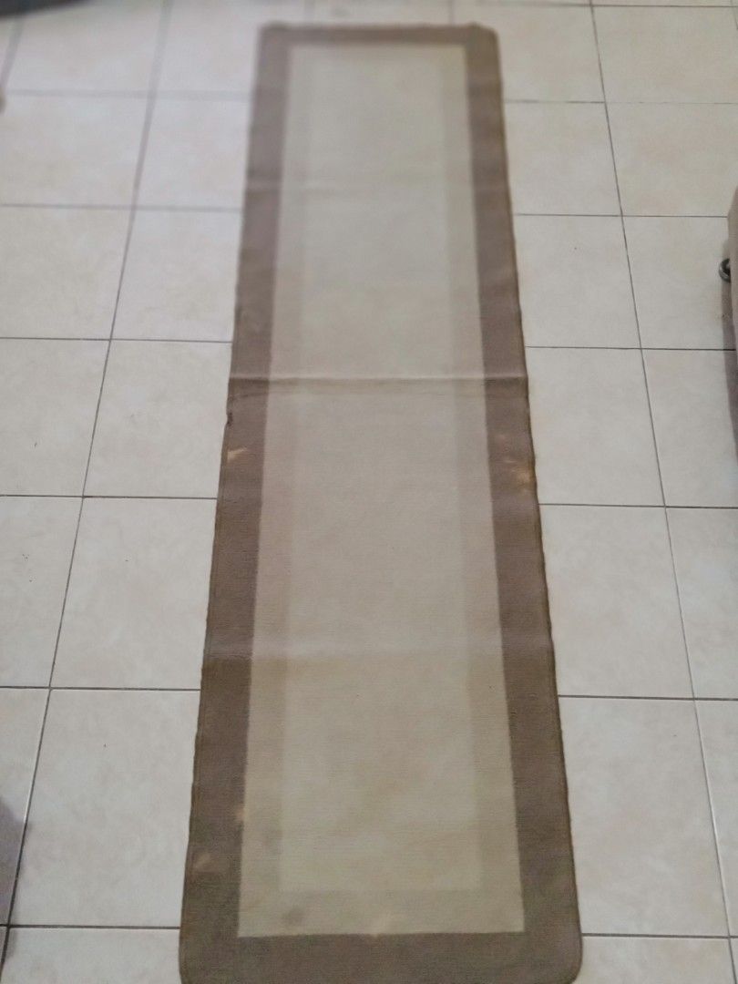Brown Runner Rug (Category: Carpets, Mats & Flooring) located in Bacoor. Submitted by luxe1820 (Listing ID 1429521977, Image 3). Description: Runner rug features a rectangular shape with a brown border and a lighter beige center. The rug is long and narrow, suitable for hallways or entryways. It has a simple, neutral design that can complement various interior styles..