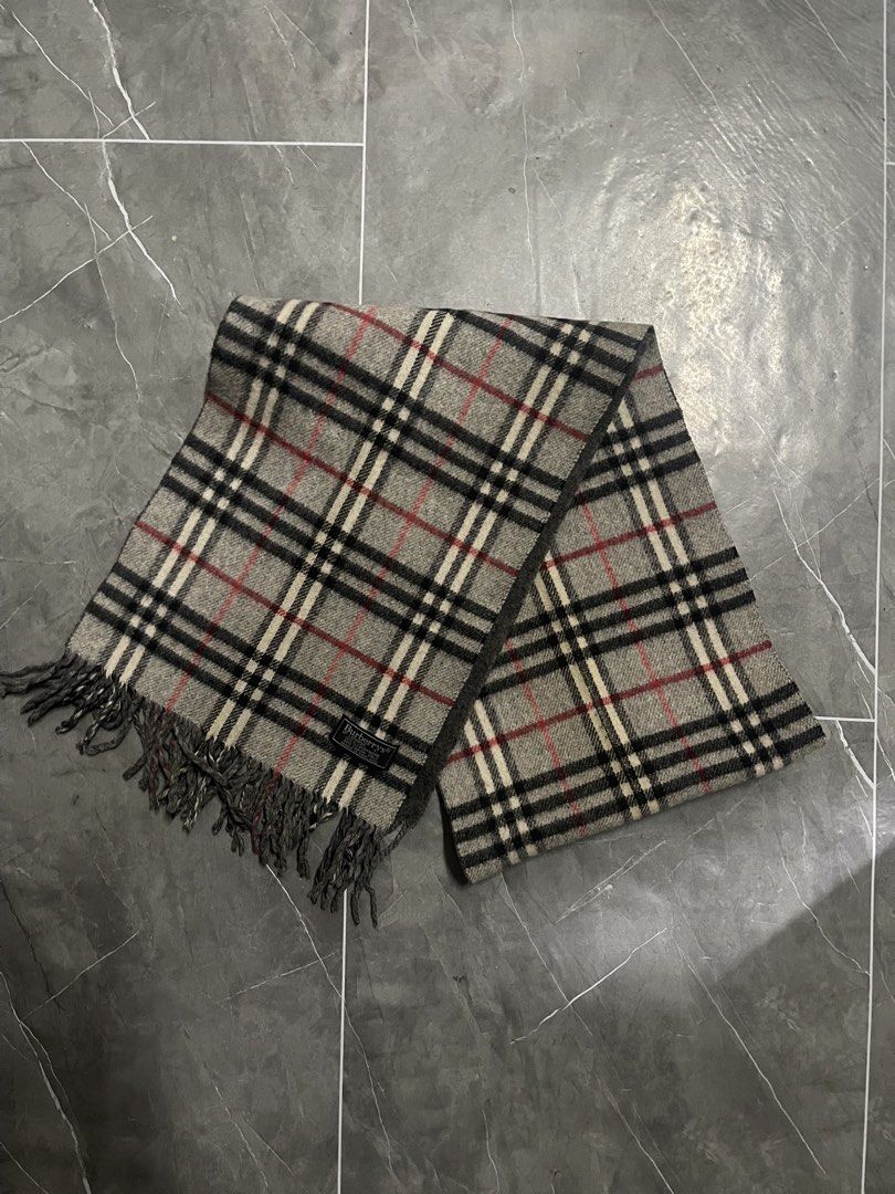 Burberry Checkered Scarf (Category: Scarves) located in Manila. Submitted by flyshitonly_1109 (Listing ID 1429508570, Image 1). Description: Authentic Burberry scarf featuring the iconic checkered pattern. The scarf has a gray base with black, white, and red accents. It includes a Burberry label. The scarf has fringed edges..