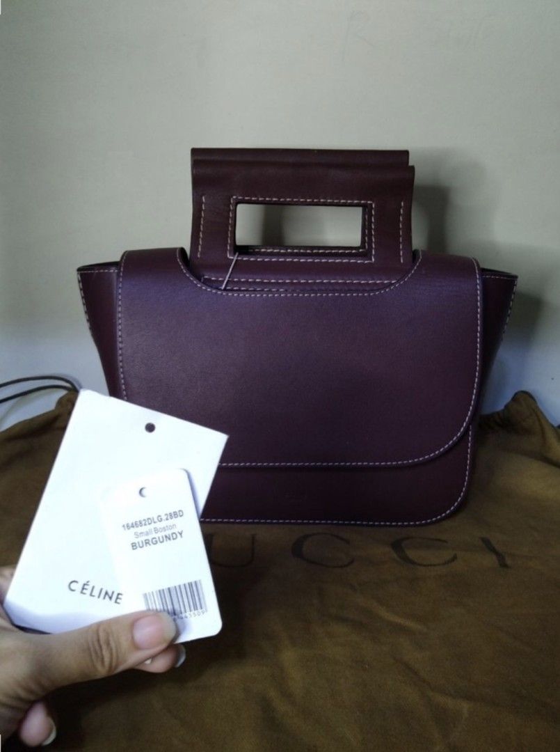 Celine Small Square Handbag Burgundy (Category: Luxury Bags & Wallets) located in Padre Garcia. Submitted by lucky_buelav (Listing ID 1429620770, Image 2). Description: Celine Small Square Handbag in burgundy. Features a unique square shape with a top handle and a flap closure. The bag has white stitching details and a small pocket on the front. Includes a dust bag. The interior has a small pocket. The style code is 184823DLG.28RO..