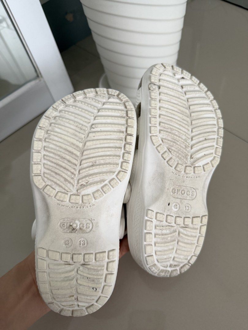 Crocs Classic Clogs - White and Green take all (Category: Babies & Kids Fashion) located in Quezon City. Submitted by reloved_finds88 (Listing ID 1429551324, Image 3). Description: - Crocs Classic Clogs for sale - White pair: Size C13, some marks - Green pair: Size C11, includes jibbitz, some dirt on soles - Both pairs show wear on soles.