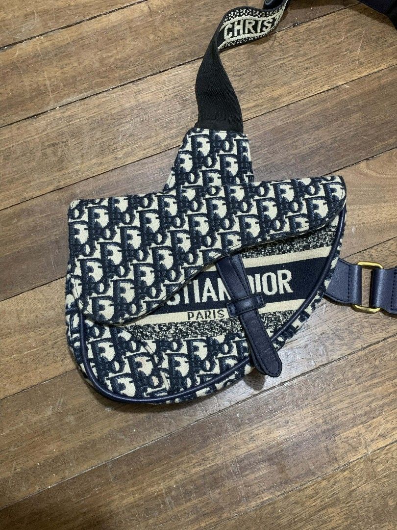 Dior Oblique Saddle Bag (Category: Luxury Bags & Wallets) located in Manila. Submitted by choychoy5859723 (Listing ID 1429606745, Image 3). Description: Authentic Dior Saddle Bag in the iconic Oblique pattern. Features a navy blue leather strap and accents. The bag has a zipper closure with a gold-tone CD zipper pull. The interior includes a leather tag with the Dior logo. The strap is adjustable and features the Christian Dior logo. Includes a n