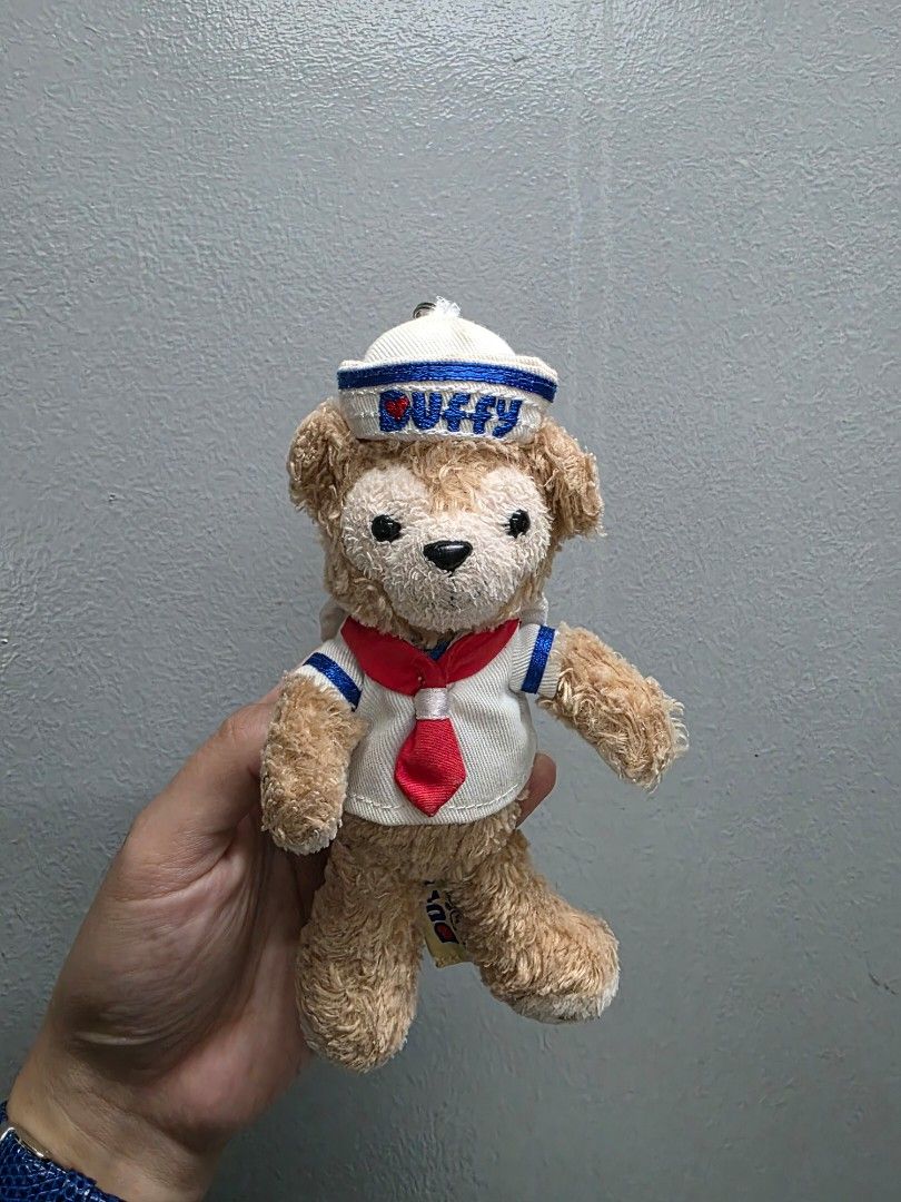 Duffy the Disney Bear Plush Keychain Sailor (Category: Plushies & Soft Toys) located in Valenzuela. Submitted by cbianx (Listing ID 1429586585, Image 1). Description: Duffy the Disney Bear plush keychain is from Hong Kong Disneyland. It features Duffy wearing a sailor outfit with a white hat. The plush has a keychain attached. The tag indicates it is an official Disney product..