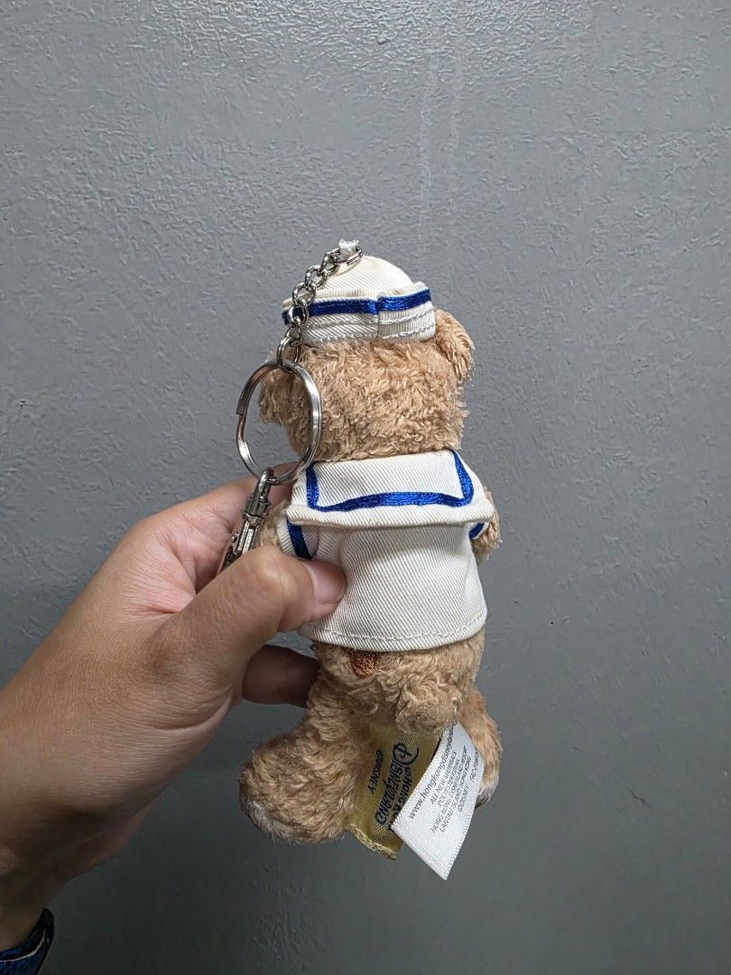 Duffy the Disney Bear Plush Keychain Sailor (Category: Plushies & Soft Toys) located in Valenzuela. Submitted by cbianx (Listing ID 1429586585, Image 2). Description: Duffy the Disney Bear plush keychain is from Hong Kong Disneyland. It features Duffy wearing a sailor outfit with a white hat. The plush has a keychain attached. The tag indicates it is an official Disney product..