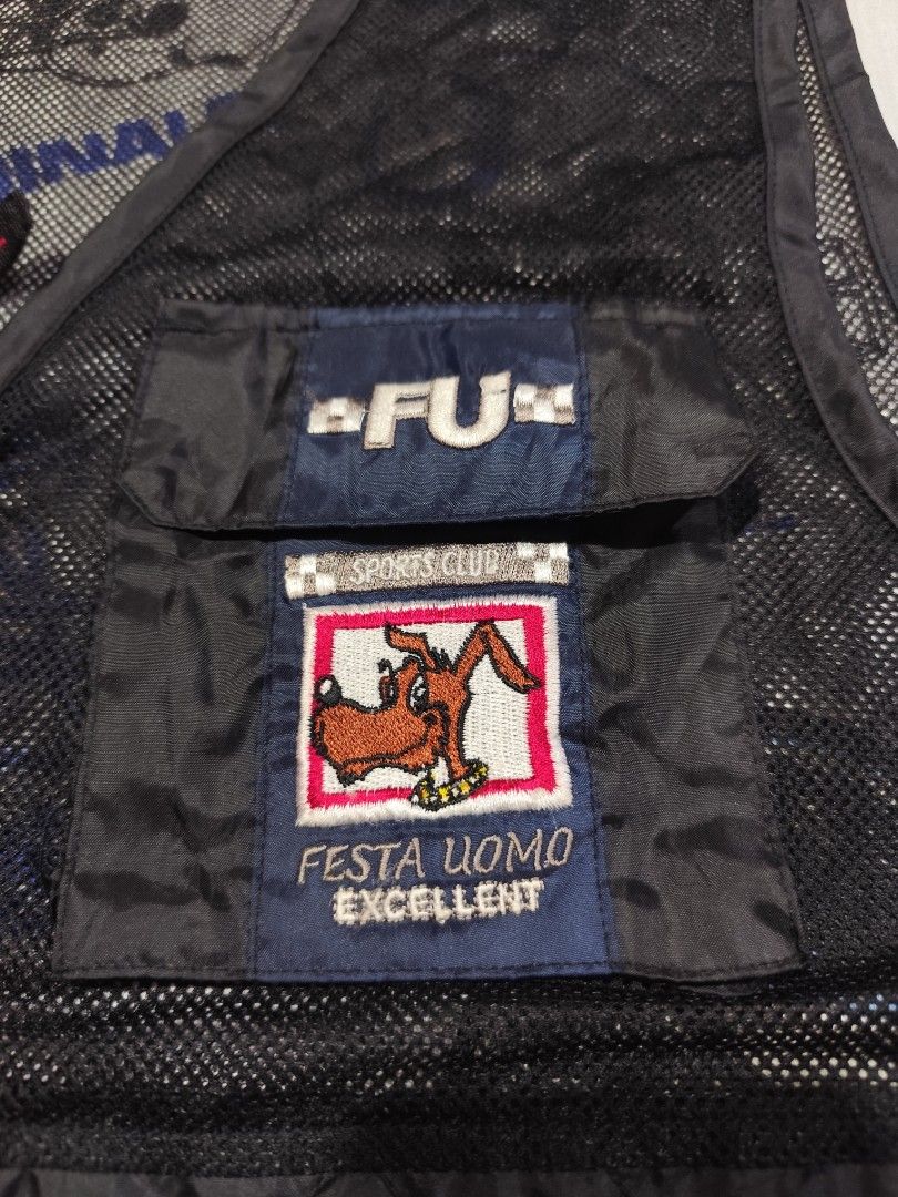 Festa Uomo Black Vest (Category: Vests) located in Baguio. Submitted by FRANKLIN (Listing ID 1429660146, Image 2). Description: Black vest from Festa Uomo. Features a zip closure and a pocket with a logo patch. The vest has a mesh upper section and a solid lower section. The size tag indicates a size M and the measurements are 22x25. The vest has a "FU" logo on the pocket..
