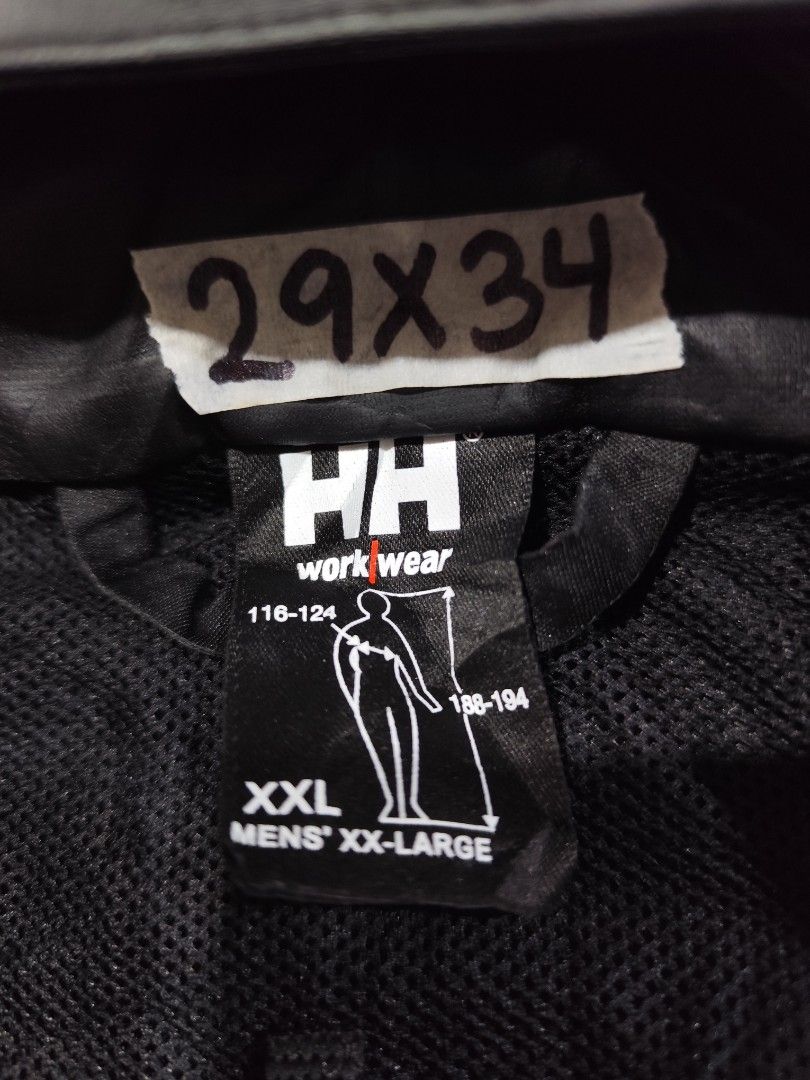 Helly Hansen Black Rain Jacket XXL (Category: Coats, Jackets and Outerwear) located in Baguio. Submitted by FRANKLIN (Listing ID 1429660129, Image 3). Description: Black Helly Hansen rain jacket. Features a hood, button closure, and two front pockets. The jacket is a men's XXL size. Made in China. Outer material is 100% PU, and the back is 100% polyester. The jacket has the HH work wear logo on the front and buttons. The jacket is designed for wo
