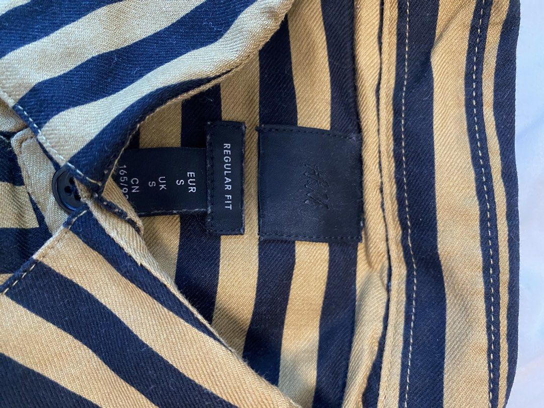 H&M Striped Shirt - Regular Fit (Category: Tshirts & Polo Shirts ) located in Makati City. Submitted by rye16 (Listing ID 1429564260, Image 2). Description: - H&M striped shirt - Color: Navy and beige - Size: Small (S) - Regular fit - Button-down - Long sleeves - Collared neckline.