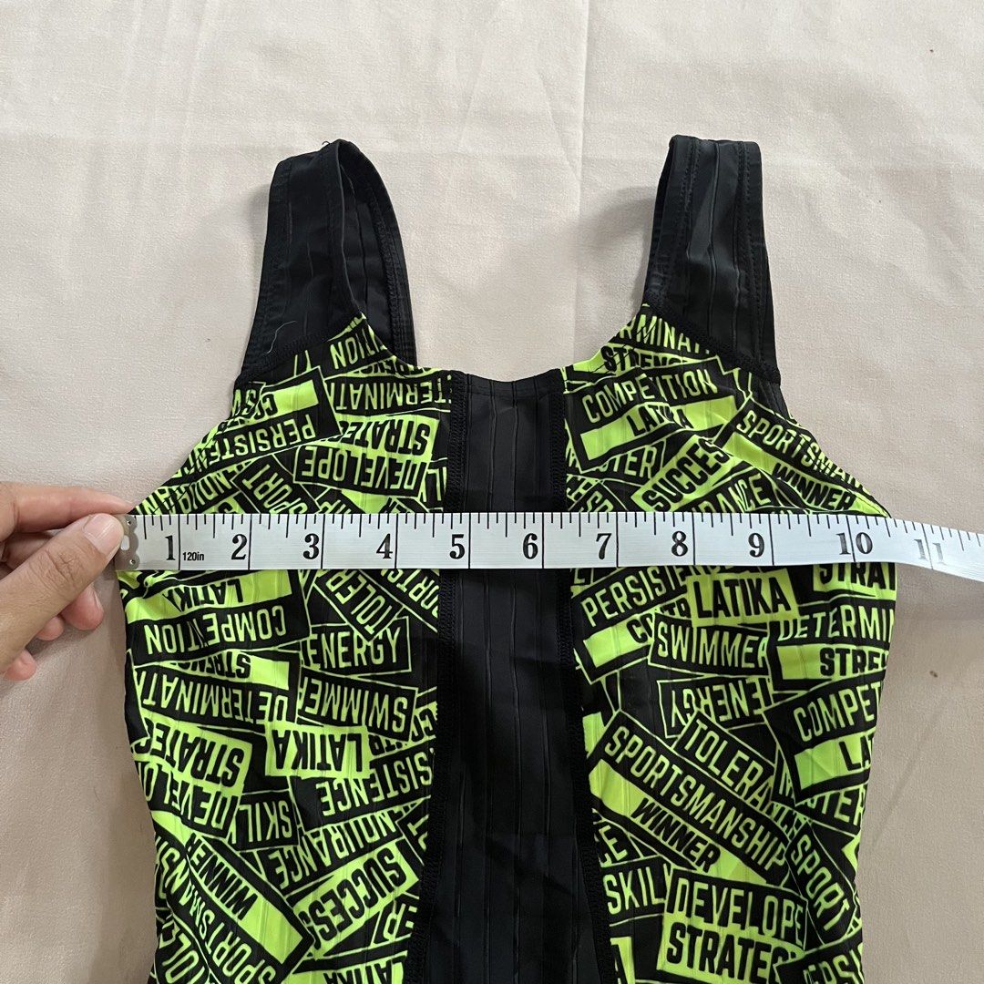 Latika Legsuit (3XS, 70cm) (Category: Babies & Kids Fashion) located in Panabo. Submitted by munch.ph (Listing ID 1429574736, Image 2). Description: Latika legsuit swimwear with a neon green and black design. Features a full-body design with a racerback style. The size is 70 (9-10). Made in Korea. The swimsuit has a unique design with words printed all over the neon green area. The material composition is 80% polyester and 20% polyurethane..