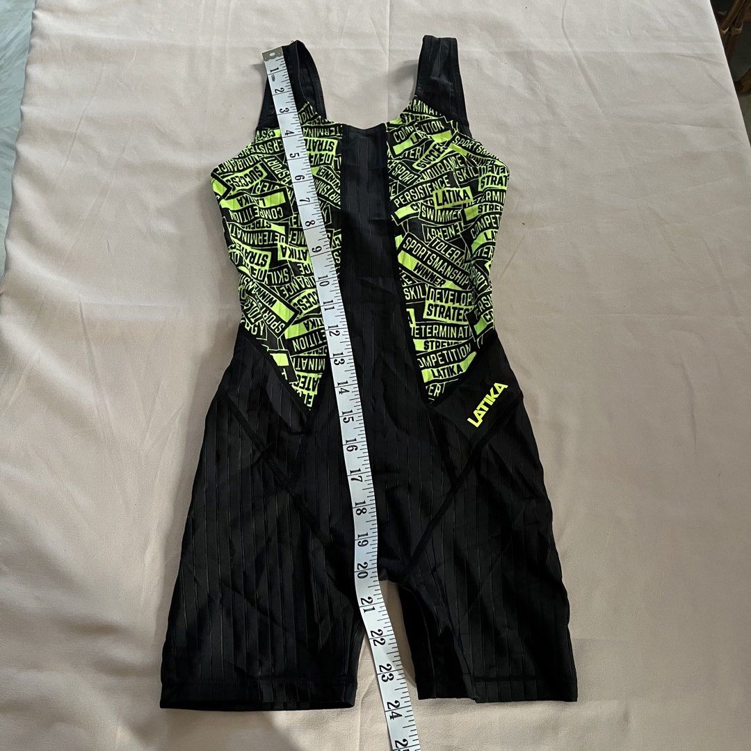 Latika Legsuit (3XS, 70cm) (Category: Babies & Kids Fashion) located in Panabo. Submitted by munch.ph (Listing ID 1429574736, Image 3). Description: Latika legsuit swimwear with a neon green and black design. Features a full-body design with a racerback style. The size is 70 (9-10). Made in Korea. The swimsuit has a unique design with words printed all over the neon green area. The material composition is 80% polyester and 20% polyurethane..
