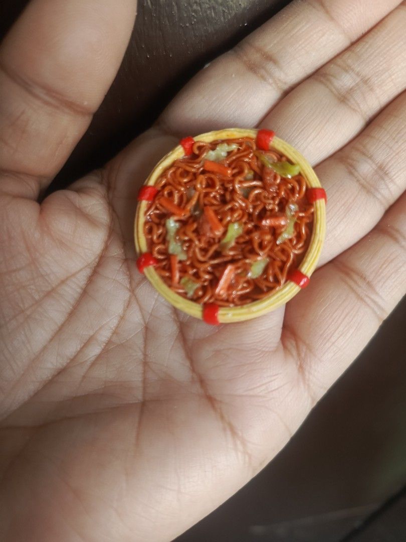 Miniature Pancit Canton in a Basket (Category: Handmade Craft) located in Manila. Submitted by jpedrina0727393 (Listing ID 1429557690, Image 1). Description: Handmade miniature pancit canton in a small woven basket. The dish features detailed noodles, vegetables, and a vibrant color scheme. Perfect for collectors of miniature food items or for use in dollhouses and dioramas. The basket has red accents around the rim. materials: polymer clay scale