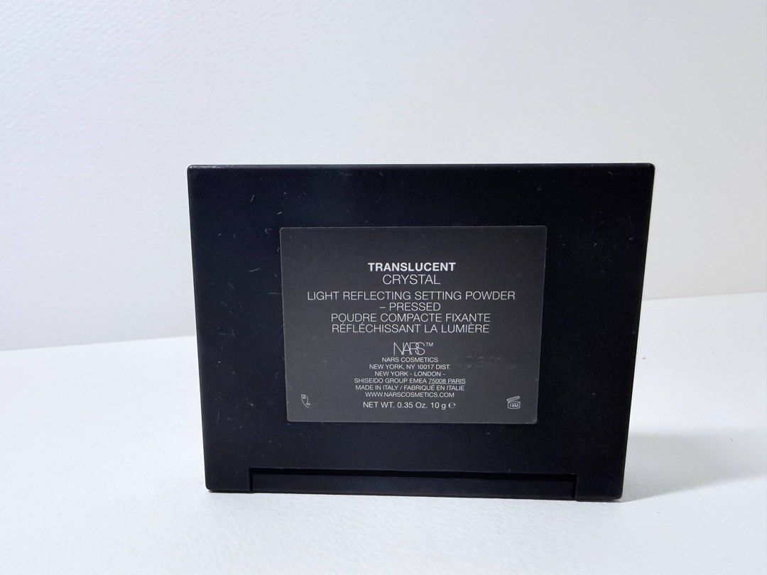 NARS Light Reflecting Setting Powder - Crystal (Category: Makeup) located in Mandaluyong City. Submitted by lgariba (Listing ID 1429610031, Image 3). Description: NARS Light Reflecting Setting Powder in Crystal. This pressed powder is designed to set makeup and provide a light-reflecting finish. The compact includes a mirror and a powder puff. The product details on the back indicate it is the translucent version. Net weight is 0.35 oz / 10 g. No