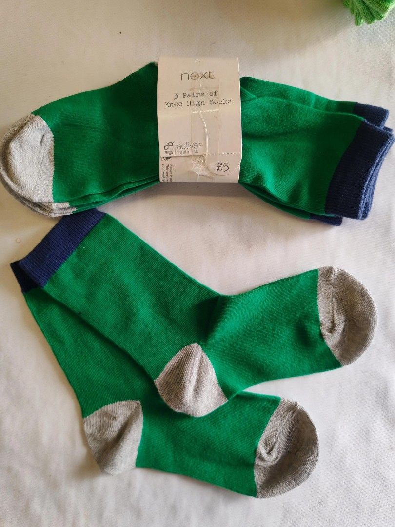 Next Knee High Socks (Category: Socks) located in Quezon City. Submitted by rowem (Listing ID 1429572209, Image 1). Description: 100 - Pair 300 - 4Pairs A pairs of knee-high socks from Next. The socks are green with grey toes and heels, and a navy blue cuff. The packaging indicates a price of £5. The socks are shown in a flat lay and also worn by a person. .