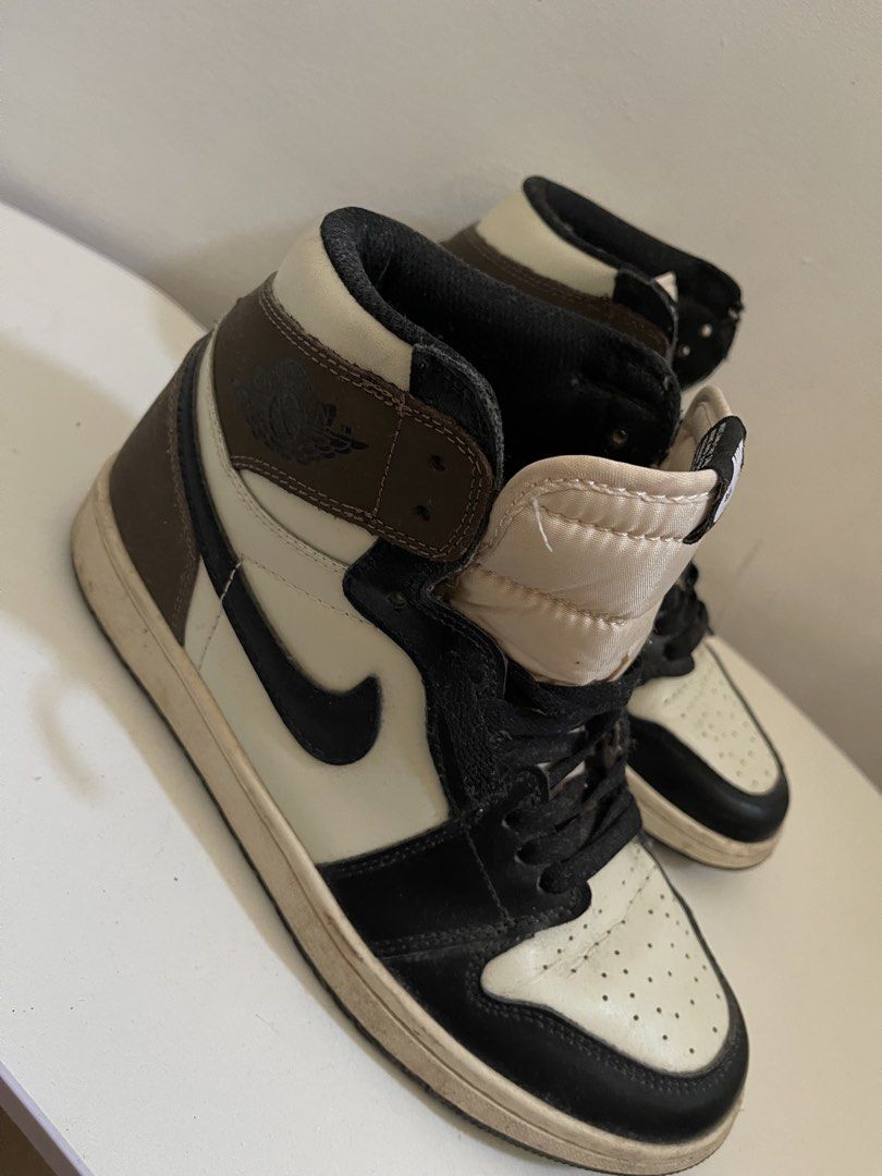 Nike Air Jordan 1 High OG (Category: Sneakers) located in Taguig. Submitted by declutterwithtally (Listing ID 1429504189, Image 2). Description: Classic Nike Air Jordan 1 High OG sneakers. Features a brown, black, and cream colorway. The iconic Nike swoosh is visible on the sides. The shoes have black laces and the Air Jordan wings logo is present. The tongue has the Nike Air logo..