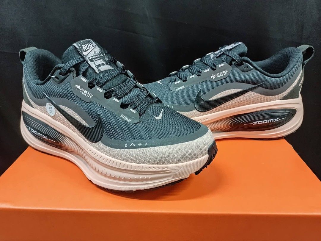 Nike ZoomX Invincible Run Flyknit Gore-Tex (Category: Sneakers) located in Taguig. Submitted by paalooksneakerhub (Listing ID 1429541946, Image 3). Description: Nike ZoomX Invincible Run Flyknit Gore-Tex sneakers. Features a dark teal upper with a pink and white sole. Includes the Nike swoosh logo on the side. The sole has a ZoomX marking. The shoes have a Gore-Tex label. The shoes are on top of an orange box..