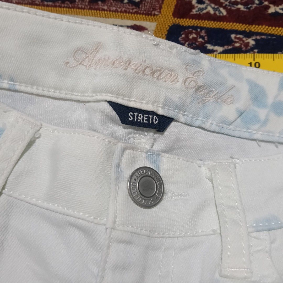 Original American Eagle Floral Print Jeans Size 4 (Category: Jeans) located in Mandaluyong City. Submitted by hailey143 (Listing ID 1415608277, Image 2). Description: - American Eagle floral print jeans - Size: 4, Regular Fit - Features: White base with blue floral pattern - Made in: China - Material: Cotton blend (cotton, polyester, spandex) - Waist: Approximately 15 inches - Inseam: Approximately 32 inches.