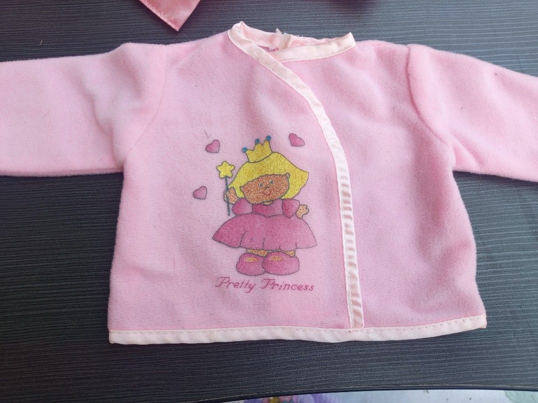 Pink Fur Baby/Doll Clothes Set (Category: Babies & Kids Fashion) located in Marikina City. Submitted by norman213 (Listing ID 1428438087, Image 2). Description: Adorable Fur baby/doll clothes set includes a pink jacket with a princess graphic, several hats, a diaper, and other accessories. The jacket has a wrap-around design with a cream-colored trim. Perfect for dressing up your doll!.