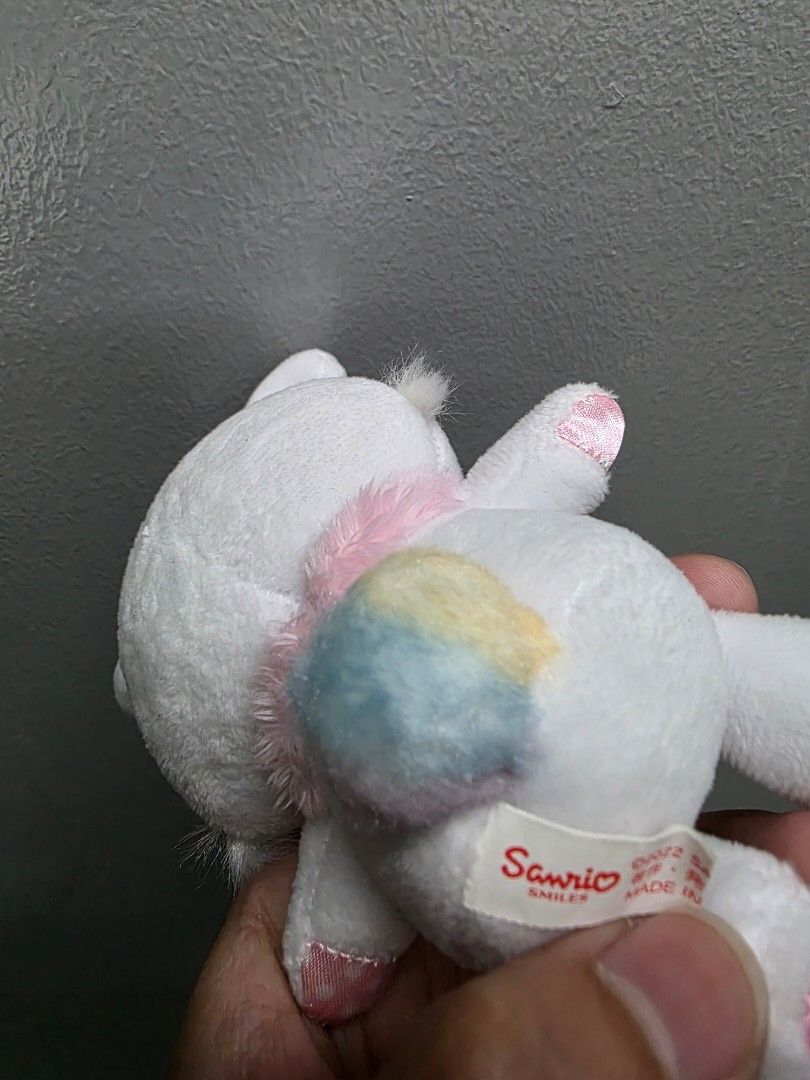 Sanrio Wish Me Mell Charm (Category: Plushies & Soft Toys) located in Valenzuela. Submitted by cbianx (Listing ID 1429586488, Image 3). Description: Adorable Sanrio wish me mell plush toy. Features a white body with pink accents on the ears and feet. It has a cute pink collar with a purple bow. The bunny has embroidered yellow eyes and a small tail. The tag indicates it is a Sanrio product..