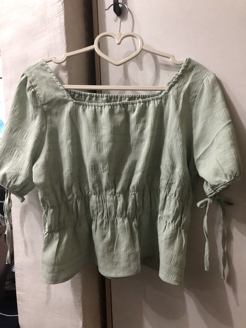 Square Neckline Top with Tie Sleeves (Category: Blouses) located in Pateros City. Submitted by downsizin (Listing ID 1429616179, Image 2). Description: With mini minimal stain‼️ Top features a square neckline and short sleeves with tie details. It has a gathered waistline and a slightly textured fabric. The top is a light green color. It is a versatile piece that can be dressed up or down..