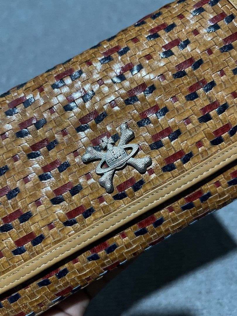 Vivienne Westwood Wallet (Category: Luxury Bags & Wallets) located in Manila. Submitted by ketchidrip.ph (Listing ID 1429568926, Image 3). Description: Authentic Vivienne Westwood wallet featuring a woven design with red and blue accents. It has a silver-tone emblem on the front and a snap closure. The interior includes multiple card slots, a zippered compartment, and the Vivienne Westwood logo. Comes with a card. Issue: Last pic.