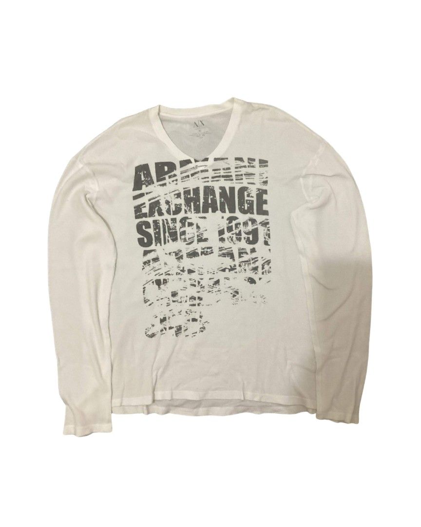 Armani Exchange Long Sleeve Shirt (Category: Tshirts & Polo Shirts ) located in Dasmarinas. Submitted by sbtt_ (Listing ID 1431327315, Image 1). Description: White long sleeve shirt from Armani Exchange. Features a V-neck and a graphic print on the front that says "Armani Exchange Since 1991". The shirt has long sleeves and a relaxed fit. Perfect for casual wear..