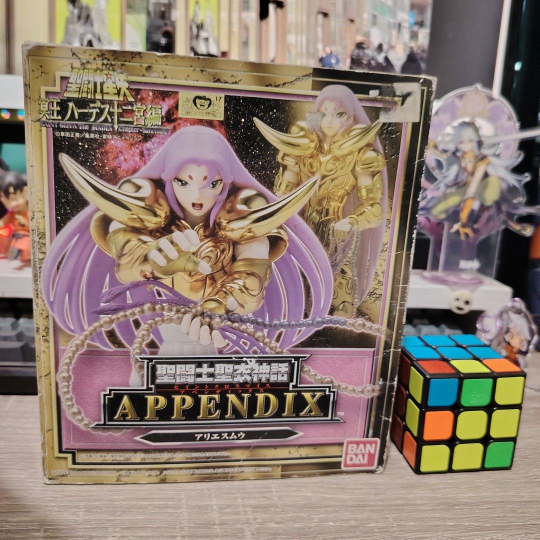 Bandai Saint Cloth Myth Appendix Aries Mu (Category: Figurines & Statues) located in Bulacan. Submitted by qilyuartstudio (Listing ID 1431276714, Image 1). Description: Bandai Saint Cloth Myth Appendix Aries Mu action figure. The box contains various parts, including armor pieces, multiple face options, and other accessories. The figure features a gold saint design. The box has Japanese text and the Bandai logo..