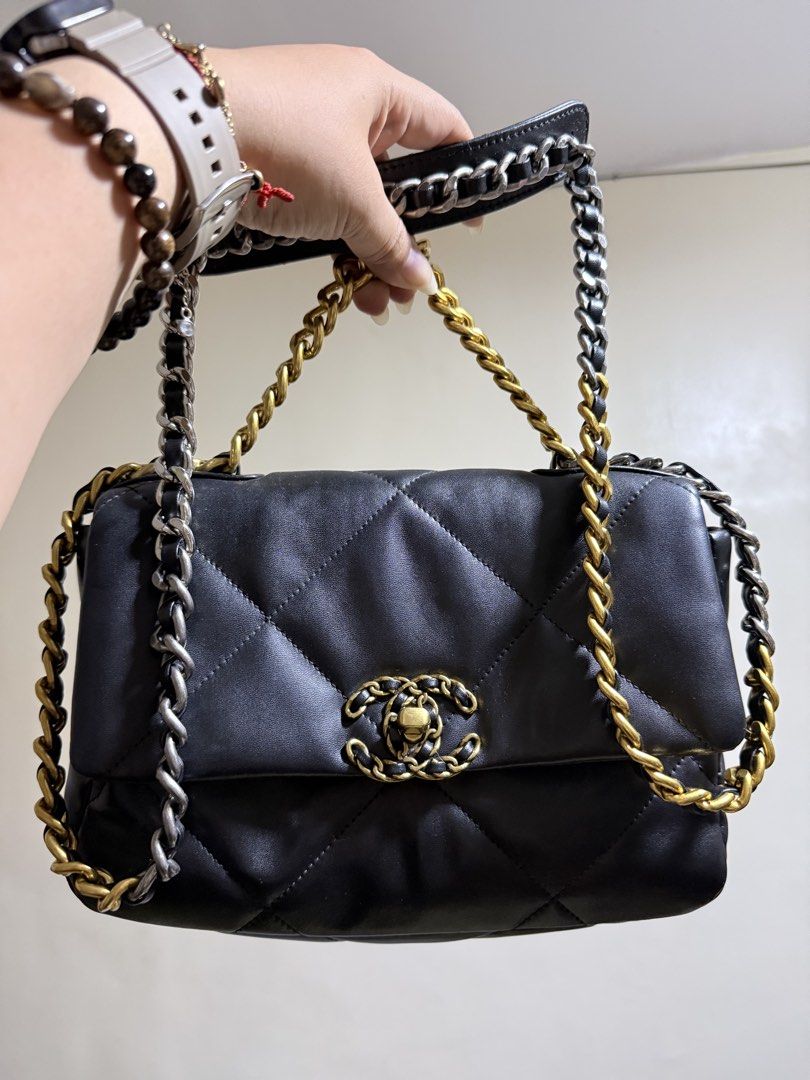 Chanel 19 Flap Bag in Lambskin (Category: Luxury Bags & Wallets) located in Cavite. Submitted by lady_speculator_ph (Listing ID 1431182853, Image 1). Description: ✨ Black Chanel 19 flap bag with gold and silver chain straps. ✨ Features a quilted design and the iconic CC turn-lock closure. ✨ 6-point star shape screw ✨ The interior has a burgundy lining with a zippered pocket. ✨ Includes a serial number tag inside. ✨ Some wear is visible on the lea