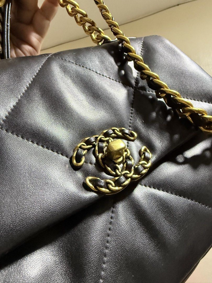 Chanel 19 Flap Bag in Lambskin (Category: Luxury Bags & Wallets) located in Cavite. Submitted by lady_speculator_ph (Listing ID 1431182853, Image 3). Description: ✨ Black Chanel 19 flap bag with gold and silver chain straps. ✨ Features a quilted design and the iconic CC turn-lock closure. ✨ 6-point star shape screw ✨ The interior has a burgundy lining with a zippered pocket. ✨ Includes a serial number tag inside. ✨ Some wear is visible on the lea